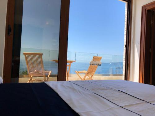 a bedroom with a bed and a view of the ocean at Villa Horus in Sveti Stefan
