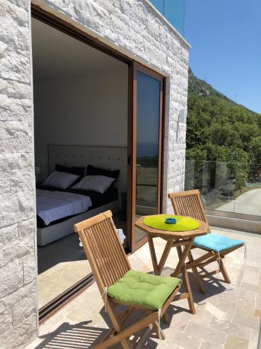a patio with a table and two chairs and a bed at Villa Horus in Sveti Stefan