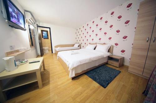 a bedroom with a bed and a wall with hearts at Pensiunea Lokanta in Daia