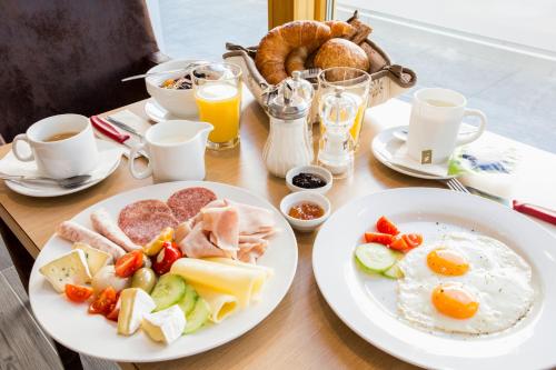 a table with two plates of breakfast food on it at Piz Ot in Samnaun