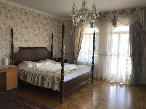 a bedroom with a bed and a chandelier at Spacious rooms in peaceful Jelgava area in Jelgava