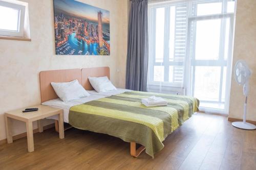 ein Schlafzimmer mit einem Bett und einem Tisch darin in der Unterkunft Sky Studio near the Vilnius Center in Vilnius