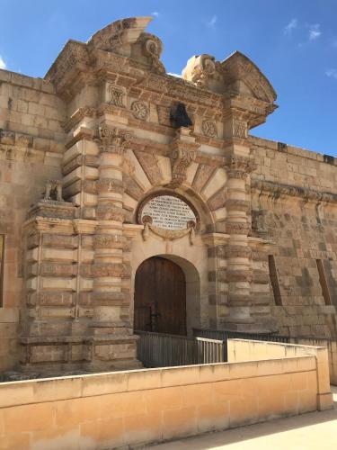 a large stone building with a large door at Pilgrim's Rest Apartments in Il-Gżira