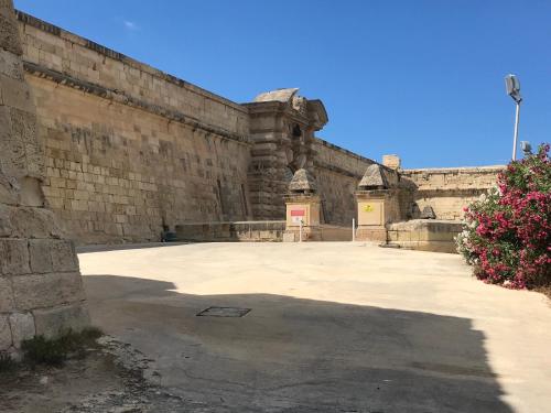an old stone building with a large courtyard at Pilgrim's Rest Apartments in Il-Gżira