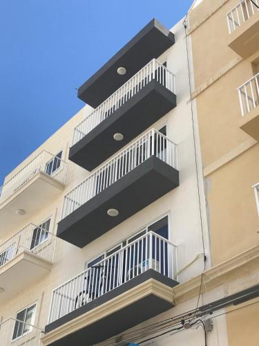 a building with balconies on the side of it at Pilgrim's Rest Apartments in Il-Gżira