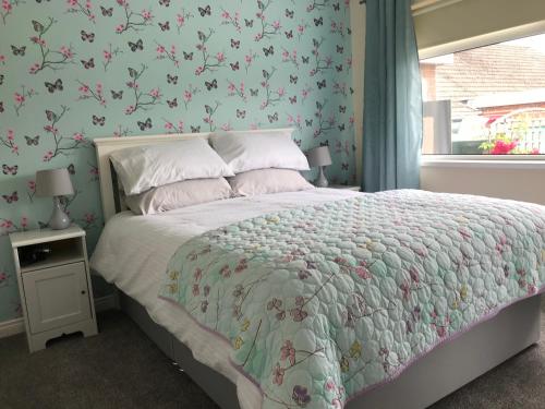 a bedroom with a bed with a floral wallpaper at Suntana at Causeway Coast and Glens in Coleraine