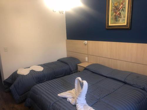 two beds in a hotel room with towels on them at Terrazza Hotel in Campos do Jordão