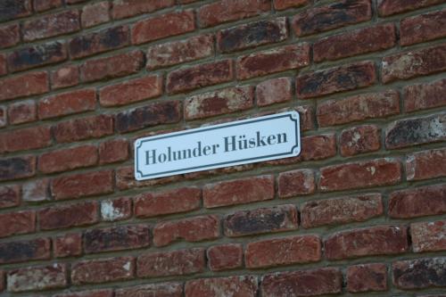 a street sign on a brick wall at Holunder Hüsken in Oberlangen