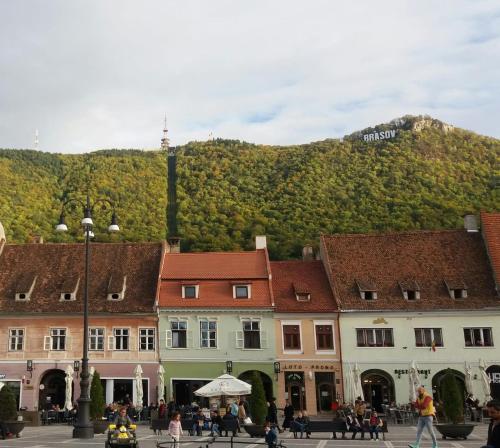 a group of buildings with a mountain in the background at 4 Rooms Piata Sfatului in Braşov