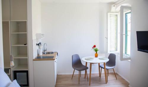 een kleine keuken met een tafel en stoelen in een kamer bij Soukki Town Centre Suites in Split