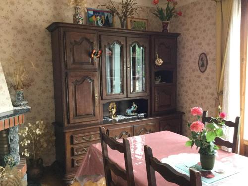 une salle à manger avec une table et une grande armoire en bois dans l'établissement Appartement indépendant dans Villa Corisande, à Bagnères-de-Bigorre
