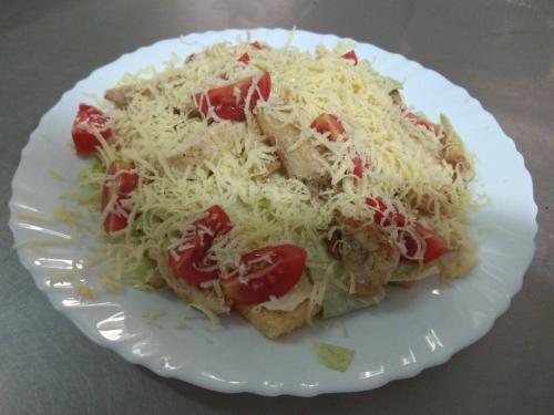 a white plate with a salad with cheese and tomatoes at Racu in Komrat