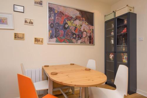 a dining room with a wooden table and a painting at Leeds city center apartment in Leeds