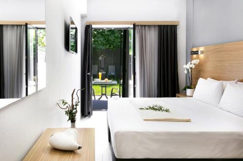 a hotel room with a bed and a balcony at Atlas Skiathos in Skiathos Town