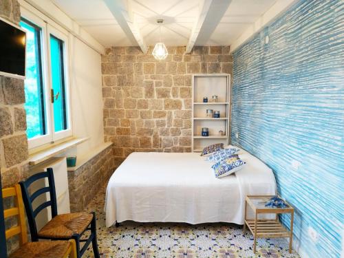 ein Schlafzimmer mit einem Bett in einer Ziegelwand in der Unterkunft La Villa in Procchio