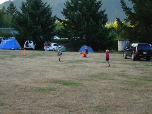 a group of people standing in a field with tents at Alpine Holiday Apartments & Campground in Hanmer Springs