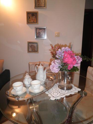 a glass coffee table with a vase of flowers on it at Apartment Punat in Punat