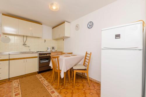 a kitchen with a table and chairs and a refrigerator at Apartments Visnja in Primošten
