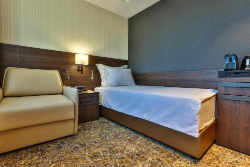 a hotel room with a bed and a chair at Hotel Zeta in Budva