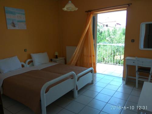 a bedroom with a bed and a sliding glass door at Alexandra Apartments in Stoupa