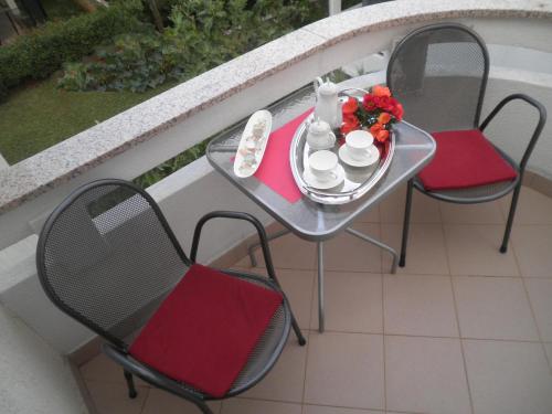 a table and chairs on a balcony with a plate of food at Apartment Punat in Punat