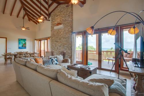 a living room with a large couch and a table at The Villas at Cocoplum in Placencia Village