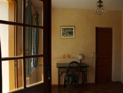 a table and a chair in a room with a window at Chambres d'Hôtes Les Pierries in Vézannes