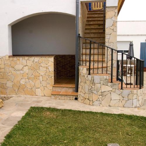 een huis met een stenen muur en een trap bij La Era in Tarifa