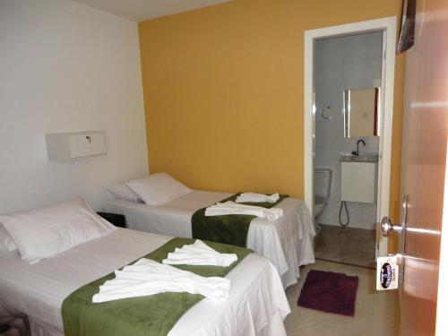 a hotel room with two beds and a bathroom at Pousada Pedacinho da Bahia in Salvador