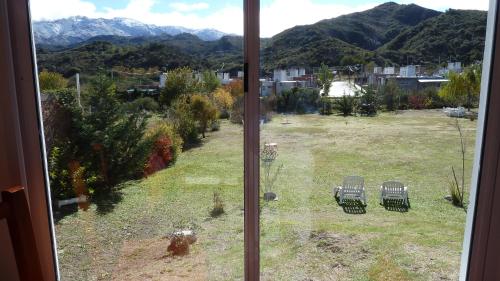 a view from a window of a yard with chairs at Hostería Los Naranjos in Potrero de los Funes