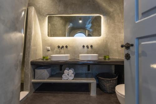 une salle de bain avec deux lavabos et un miroir dans l'établissement NK Cave House Villa, à Fira