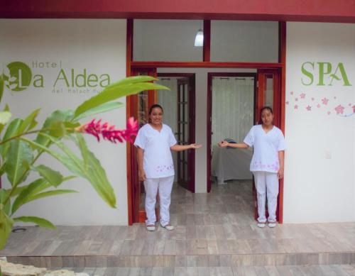 two women standing in front of a building at Hotel La Aldea del Halach Huinic in Palenque