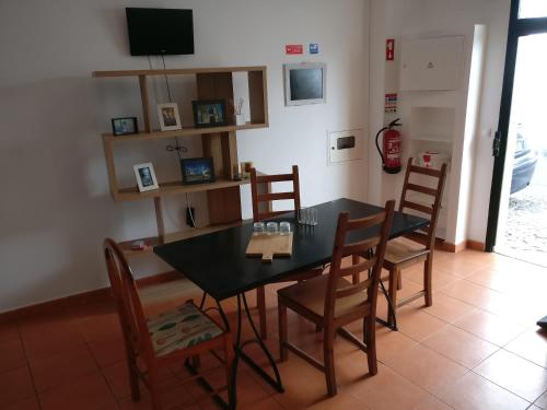 a dining room with a black table and chairs at Casas do Megué in Évora