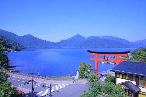 an orange torii gate next to a body of water at Hotel Hanaan in Nikko