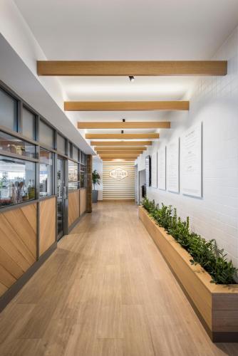 a hallway in a building with wooden floors and plants at Lakes Hotel in Adelaide
