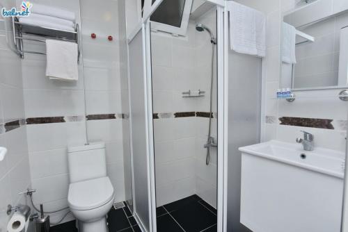 a bathroom with a toilet and a sink at Tunan Motel in Ayvalık