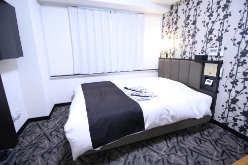 1 dormitorio con cama y ventana grande en APA Hotel Hikoneminami, en Hikone