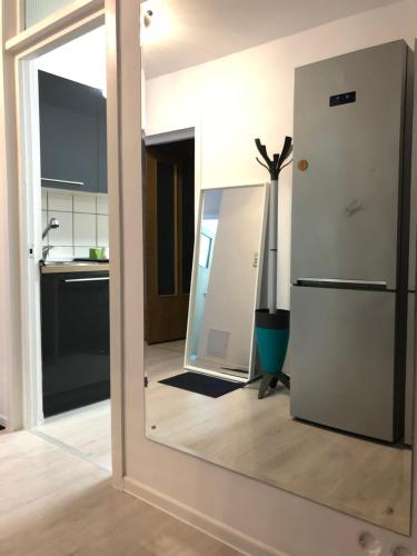 a kitchen with a mirror and a refrigerator at Green Apartment 59 in Bucharest