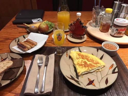 a wooden table topped with plates of breakfast food at A La Carte Bed & Breakfast in Montréal
