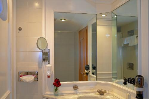 a bathroom with a sink and a large mirror at Seehotel Waltershof in Rottach-Egern