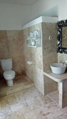 a bathroom with a toilet and a sink at Puri Oka Beach Bungalows in Candidasa