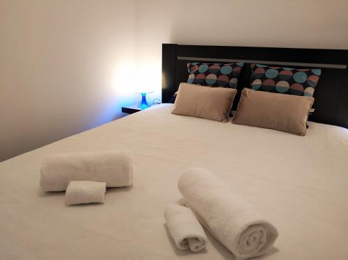 a bed with white sheets and pillows on top of it at Sleep & Go Faro Airport Guest House in Faro