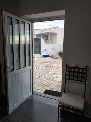 an open door with a chair in front of a patio at Sleep & Go Faro Airport Guest House in Faro