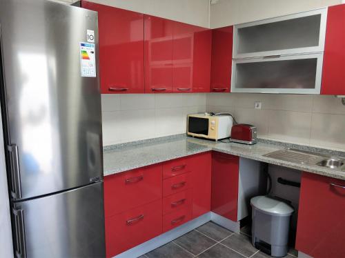 
a kitchen with a refrigerator, microwave, sink, and dishwasher at Sleep & Go Faro Airport Guest House in Faro
