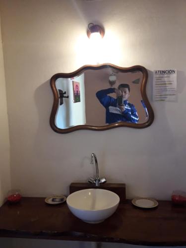 a bathroom with a sink and a mirror on the wall at Hostal Rustyk in Cafayate