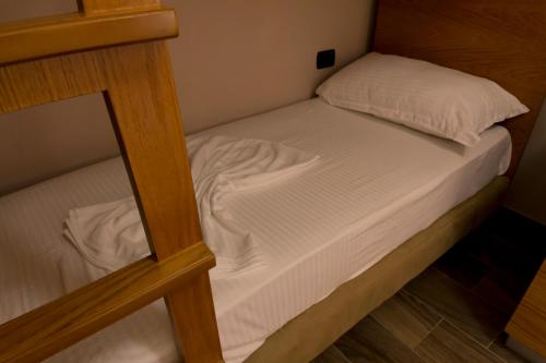 a small bed in a small room with a mirror at Hotel Pandora Residence in Tirana