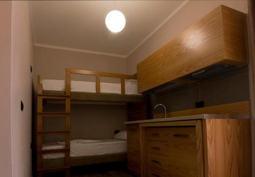a small bedroom with bunk beds and a sink and a light at Hotel Pandora Residence in Tirana