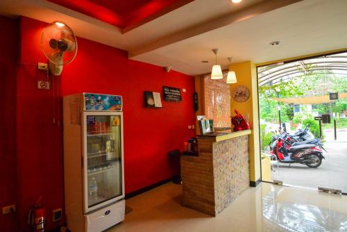 un restaurant avec un mur rouge et un réfrigérateur dans l'établissement Gecko Hotel, à Bophut 