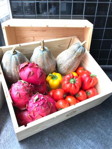 a wooden crate filled with different types of vegetables at Single Inn-Kaohsiung Station in Kaohsiung