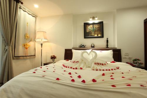 a bedroom with a white bed with red hearts on it at Hanoi Siva Luxury Hotel & Travel in Hanoi